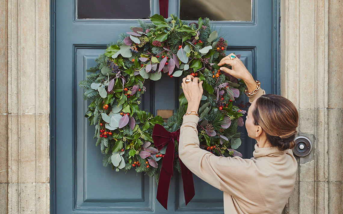 putting wreath on a door
